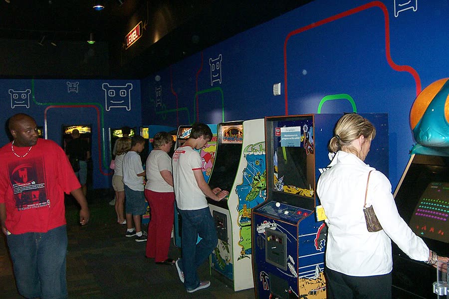 People playing classic arcade cabinets