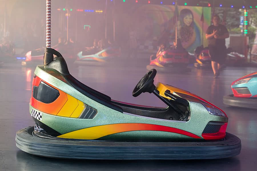 A colorful bumper car under arcade lights