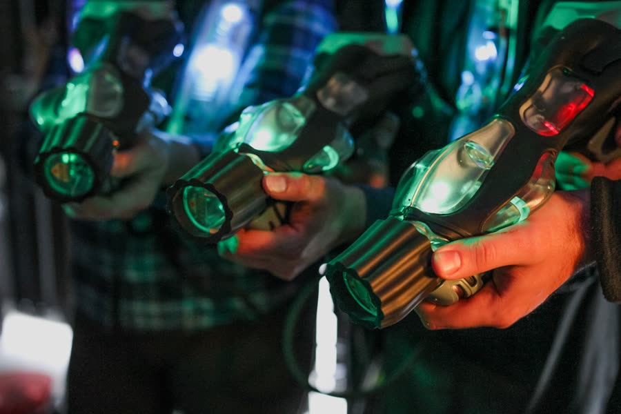 Players holding glowing laser tag blasters